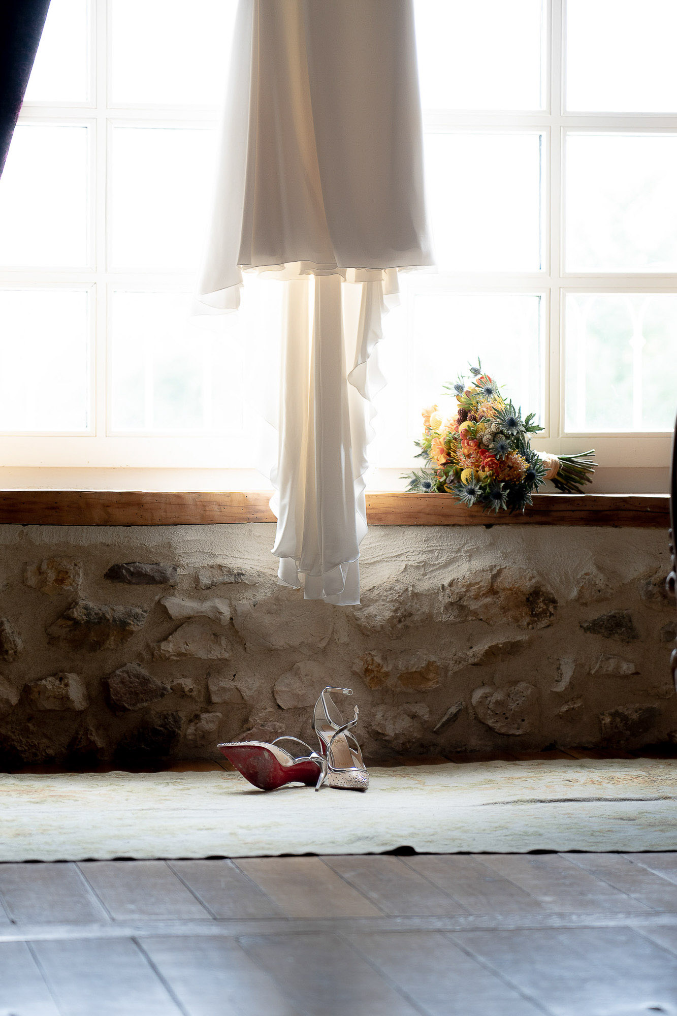 La robe suspendue à une fenêtre ensoleillée, le bouquet posé La robe suspendue à une fenêtre ensoleillée, le bouquet posé